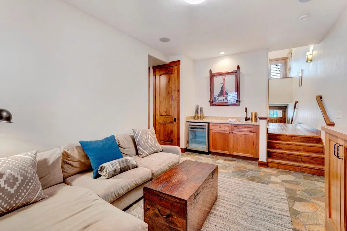 A kitchenette adjacent to a comfortable seating area, featuring a sofa, coffee table, and decorative touches. The open-plan design encourages seamless interaction between the kitchen and living space, ideal for shared meals and relaxed gatherings.