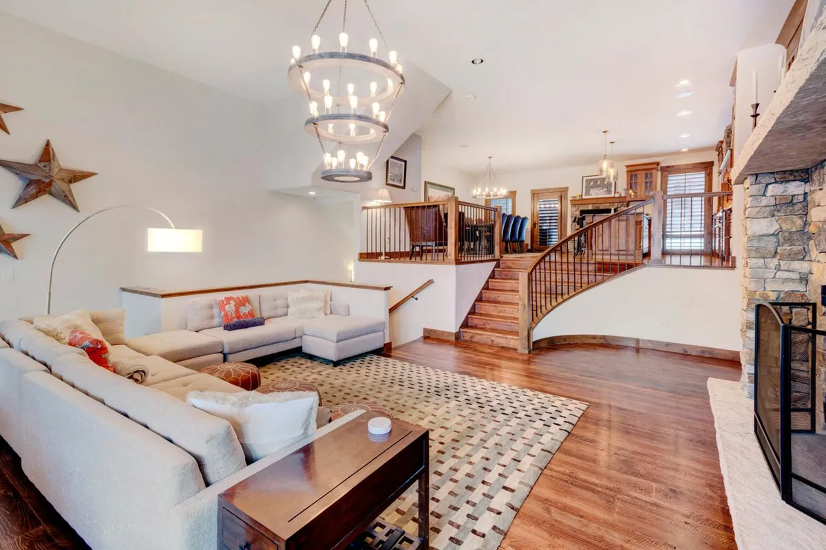 A spacious living area with a comfortable sofa, warm fireplace, and decorative elements like a chandelier and festive stars. The setting is perfect for family gatherings, entertaining friends, or simply relaxing, suggesting hospitality and versatility for different seasons.