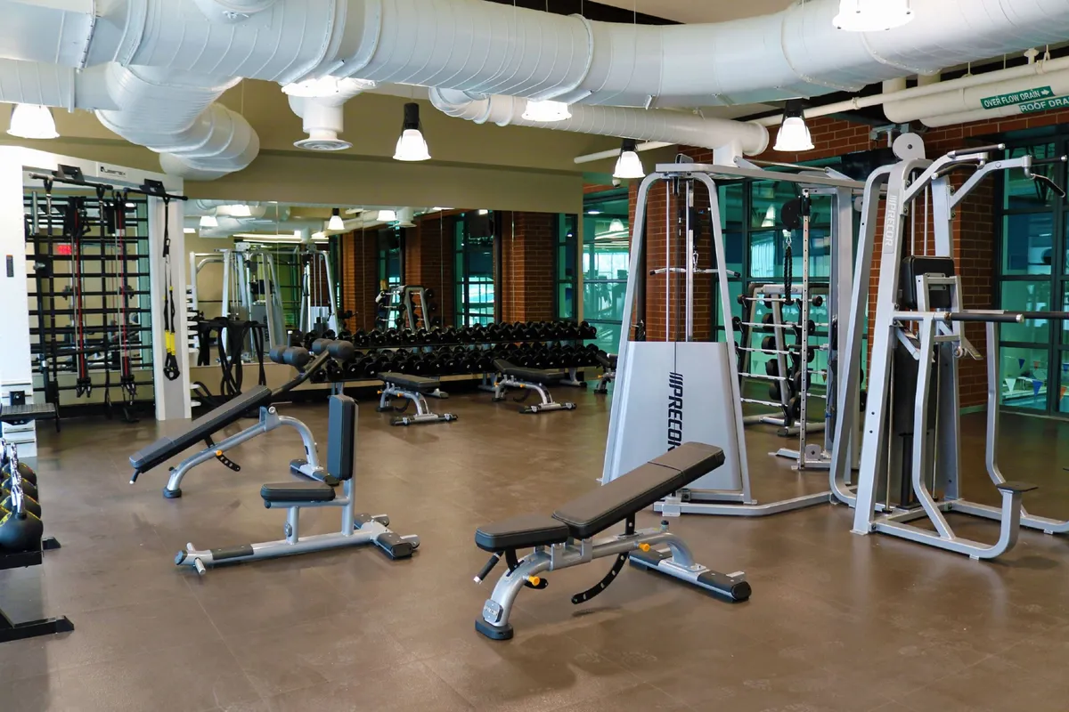 A well-equipped fitness center featuring a dumbbell rack, weight machines, and benches, creating a motivational environment for guests to pursue their wellness routines.